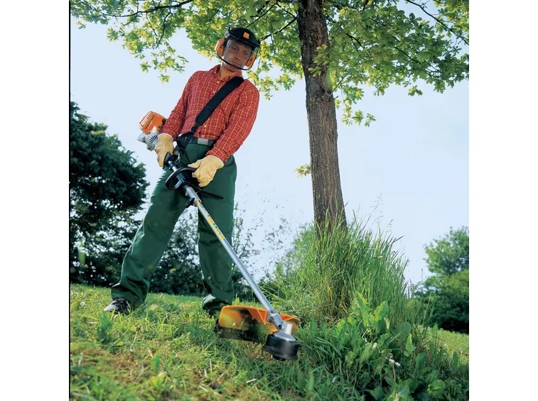 Un lavoratore equipaggiato di decespugliatore