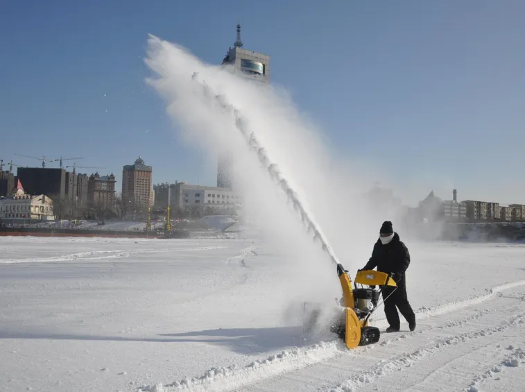 uomo con turbina da neve in paesaggio cittadino