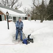 uomo con turbina neve nel cortile